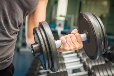 el bir dumbbell tutarak.