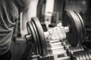 el bir dumbbell tutarak.