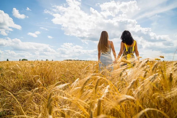 Mädchen stehen in einem Weizenfeld. — Stockfoto