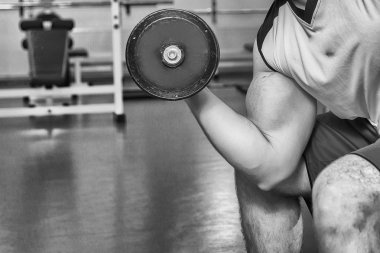 adam dumbbells ile çalışmaları yapan.