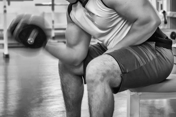 Homem faz exercícios com halteres . — Fotografia de Stock