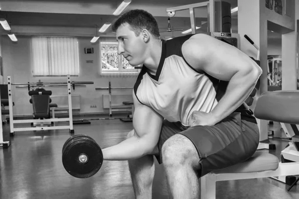 Adam dumbbells ile çalışmaları yapan. — Stok fotoğraf