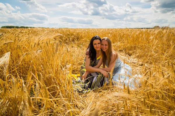 Meisjes in een tarweveld — Stockfoto