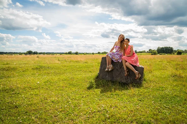 Meisjes zitten op steen — Stockfoto