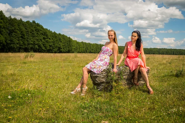 Flickorna sitter på sten — Stockfoto