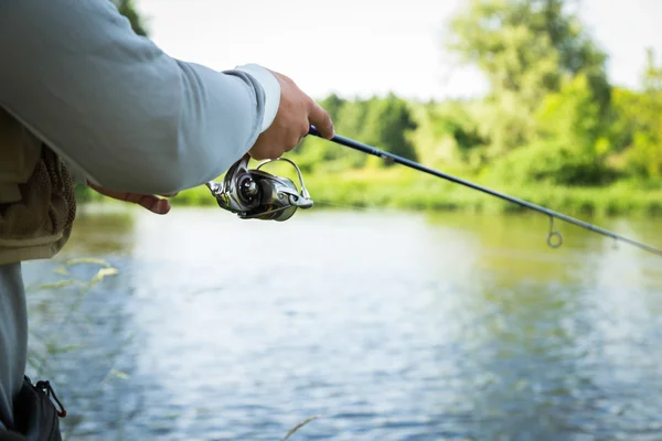 Fisherman holding spinning — Stock Photo, Image