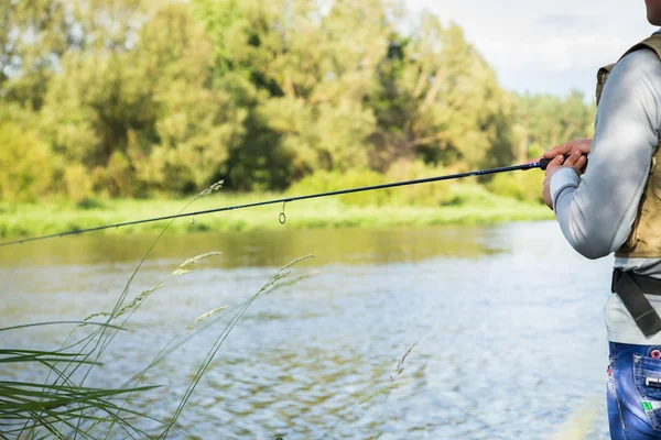 Fisherman holding spinning — Stock Photo, Image