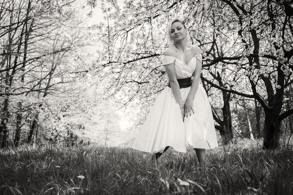 Blonde in white dress in the spring garden