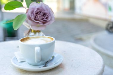 Bir kafede bir fincan kahve ve çiçekler.