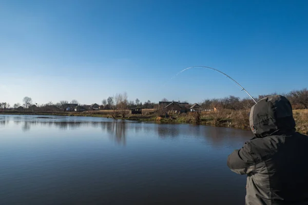 ロッドを持つ漁師 湖の上にリールを回転 — ストック写真