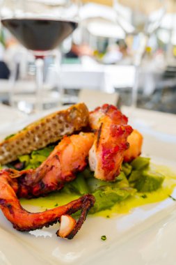 Izgara kalamar, sebzeli ve beyaz tabakta ekmek.