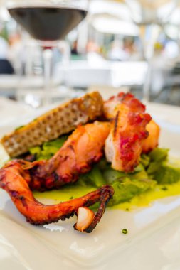 Izgara kalamar, sebzeli ve beyaz tabakta ekmek.