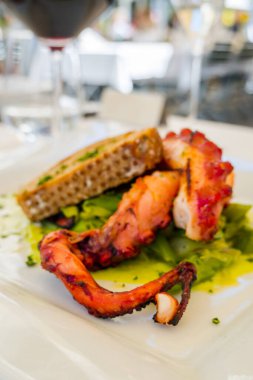 Izgara kalamar, sebzeli ve beyaz tabakta ekmek.