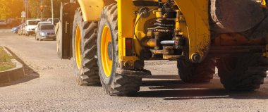 Ağır makineler, inşaat alanında traktör, büyük tekerleklere yakın çekim, afiş fotoğrafı.