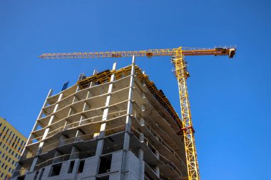 Büyük inşaat alanları ve sarı vinç çalışıyor, endüstri yeni inşaat sektörü konsepti, mavi gökyüzü arka planı 