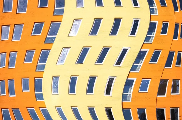 Conceito de arquitetura europeia moderna. Residência urbana multi-andares edifício multi-colorido com muitas janelas de vidro, design embrulhado — Fotografia de Stock
