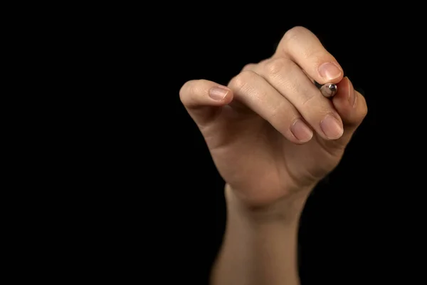 Hand is holding pen isolated on black background, pointing idea, make a note concept, copy space