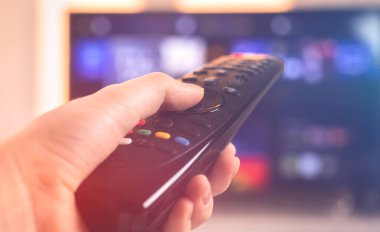 Uzaktan kumandalı konsept kişi oturma odasında televizyon izliyor, seçici odak fotoğrafı