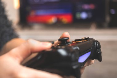 Kişi evdeki bir konsol üzerinde video oyunu oynamak için kablosuz denetleyici kullanın, joystick 'in yakın görüntüsü 