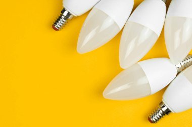 Ev lambaları, sarı arka plan. Enerji tasarrufu ve çevre dostu ampuller. Düz konum, üst görünüm, uzay fotoğrafını kopyala