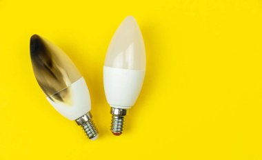 Yangından sonra LED ampulü. Elektrik kısa devre kavramı. Evde yanan tel, tehlikeli, başarısız. Ev güvenliği. Üst manzara, sarı arkaplan 