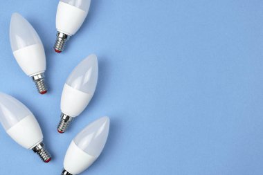 Eko LED ampuller, pastel mavi arka plan. Enerji tasarrufu kavramı. Düz konum, üst görünüm, kopyalama alanı