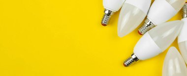 Pankart, enerji tasarruflu LED ampuller, sarı arka plan. Düz konum, üst görünüm, uzay fotoğrafını kopyala