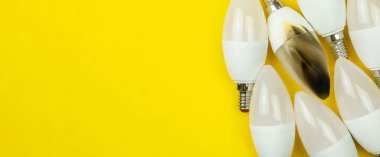 Pankart, yanan LED ampuller, elektrik kısa devre konsepti. Ev güvenliği. Üst görünüm, kopyalama alanı, sarı arkaplan fotoğrafı