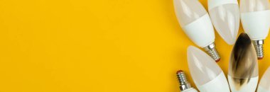 Yangından sonra kırık LED ampul, ev güvenliği konsepti, kısa devre. Evde yanan tel, tehlikeli, başarısız. Geniş pankart, üst manzara, turuncu arkaplan fotoğrafı