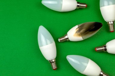 Kırık, hasarlı ve yanıp sönen LED ampuller, yeşil arka plan