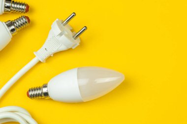 LED ampullerle yeşil enerji verimliliği ve AB prizli elektrik kablosu. Sarı arkaplan, düz yatay ve üst görünüm