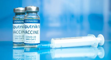Kharkov, Ukrayna - 3 Kasım 2021: Sputnik V COVID-19 aşısı. Coronavirus aşı şişesi hastane arka planındaki cam masanın üzerinde.