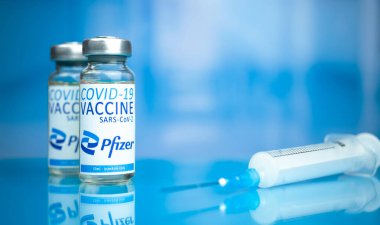 Kharkov, Ukrayna - 3 Kasım 2021: Pfizer COVID-19 aşısı. Coronavirus aşı tüpleri ve şırınga hastane arka planındaki cam masanın üzerinde.