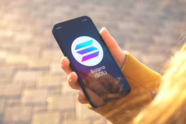 Solana SOL şifreleme sembolü. İş ve finansal konsept. Akıllı telefonlu el, kripto logolu ekran yakın plan