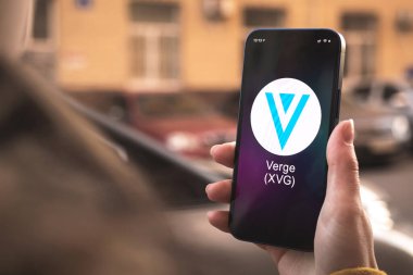 XVG şifreleme sembolü, logo. İş ve finansal konsept. Akıllı telefon ile el, kripto simgesi ile ekran kapatma