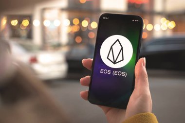 EOS kripto para birimi sembolü, logo. İş ve finansal konsept. Akıllı telefon ile el, kripto simgesi ile ekran kapatma