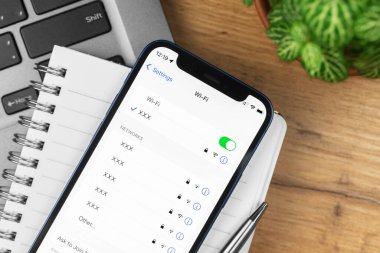 Kharkov, Ukrayna - 21 Kasım 2021: Apple iPhone 'daki Wi-Fi ayarları. İş yeri, ahşap masa, üst manzara. 