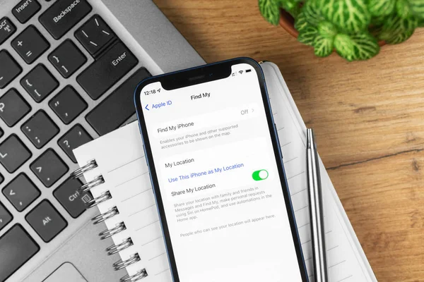 Kharkov, Ukrayna - 21 Kasım 2021: Apple iPhone 'daki telefon ayarlarımı bul. İş yeri, ahşap masa, üst manzara. 
