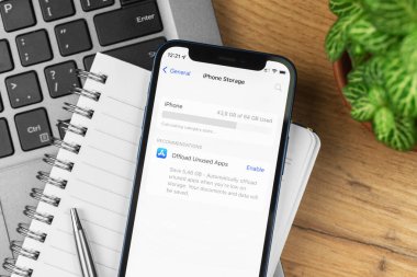 Kharkov, Ukrayna - 21 Kasım 2021: iPhone depolama ekranı. İş yeri, ahşap masa, üst manzara.