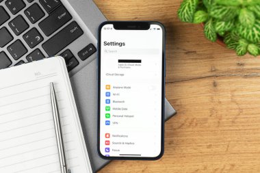 Kharkov, Ukrayna - 21 Kasım 2021: Apple iPhone 'daki ayarlar. İş yeri, ahşap masa, üst manzara. 