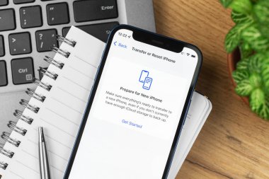 Kharkov, Ukrayna - 21 Kasım 2021: Apple iPhone 'da veri aktarım ekranı. İş yeri, ahşap masa, üst manzara.