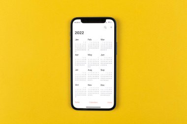 Kharkov, Ukrayna - 17 Kasım 2021: Apple iPhone ekranında 2022 takvimi. Takvim uygulaması. İş alanı, üst görünüm 