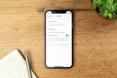 Kharkov, Ukrayna - 21 Kasım 2021: Apple iPhone 'dan telefonumu bul. Ahşap masa arkaplanı