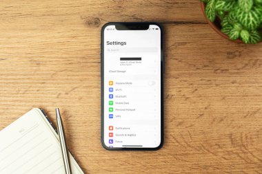 Kharkov, Ukrayna - 21 Kasım 2021: Apple iPhone 'da ekran kuruluyor. Ahşap masa arkaplanı