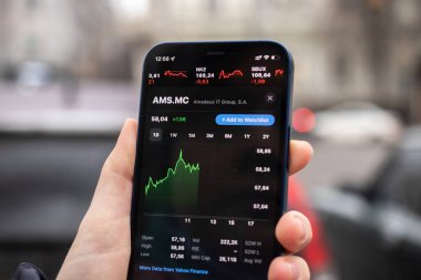 Harkov, Ukrayna - 1 Aralık 2021: Amadeus AMS MC hisse senedi ticareti. Finansal grafikler, yatırım, dijital bankacılık konsepti fotoğrafı. Elinde borsa uygulaması olan akıllı telefon. 