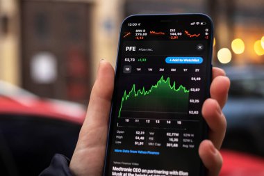Kharkov, Ukrayna - 1 Aralık 2021: Pfizer Inc. Finansal grafikler, yatırım, dijital bankacılık konsepti fotoğrafı. Elinde borsa uygulaması olan akıllı telefon. 