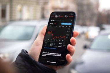 Kharkov, Ukrayna - 1 Aralık 2021: Exxon Mobil Ekin. XOM borsası. Finansal grafikler, yatırım, dijital bankacılık konsepti fotoğrafı. Elinde borsa uygulaması olan akıllı telefon. 