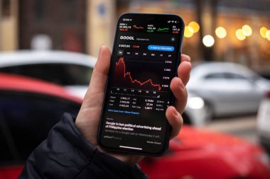 Kharkov, Ukrayna - 1 Aralık 2021: Google GoOGL hisse senedi ticareti. Finansal grafikler, yatırım, dijital bankacılık konsepti fotoğrafı. Elinde borsa uygulaması olan akıllı telefon. 