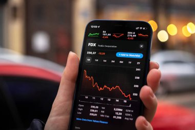 Harkov, Ukrayna - 1 Aralık 2021: FedEx FDX hisse senedi ticareti. Finansal grafikler, yatırım, dijital bankacılık konsepti fotoğrafı. Elinde borsa uygulaması olan akıllı telefon. 