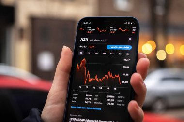 Kharkov, Ukrayna - 1 Aralık 2021: AstraZeneca borsası. Finansal grafikler, yatırım, dijital bankacılık konsepti fotoğrafı. Elinde borsa uygulaması olan akıllı telefon. 